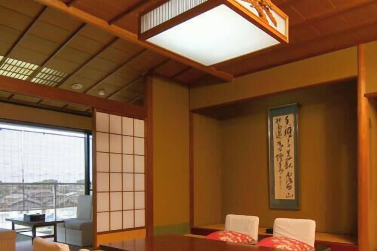 Une pièce de style japonais traditionnel, avec un sol recouvert de tatamis, une table basse et des paravents en papier de riz (shoji).