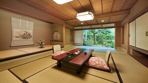 A traditional Japanese room with tatami flooring, a low table, and sliding doors. - Awazu-Spa Tourist Hotel Kitahachi (Komatsu)