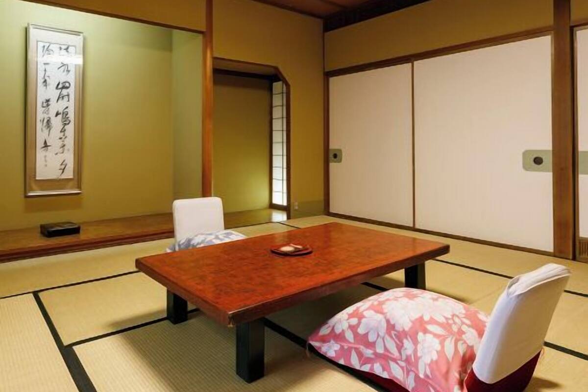 Une pièce de style japonais traditionnel, avec un sol recouvert de tatamis, une table basse et une porte coulissante en papier de riz (shoji).