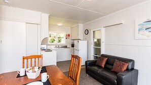 Maison (Waitangi Beach Bach 30B) | Aire de séjour | Téléviseur à écran plat