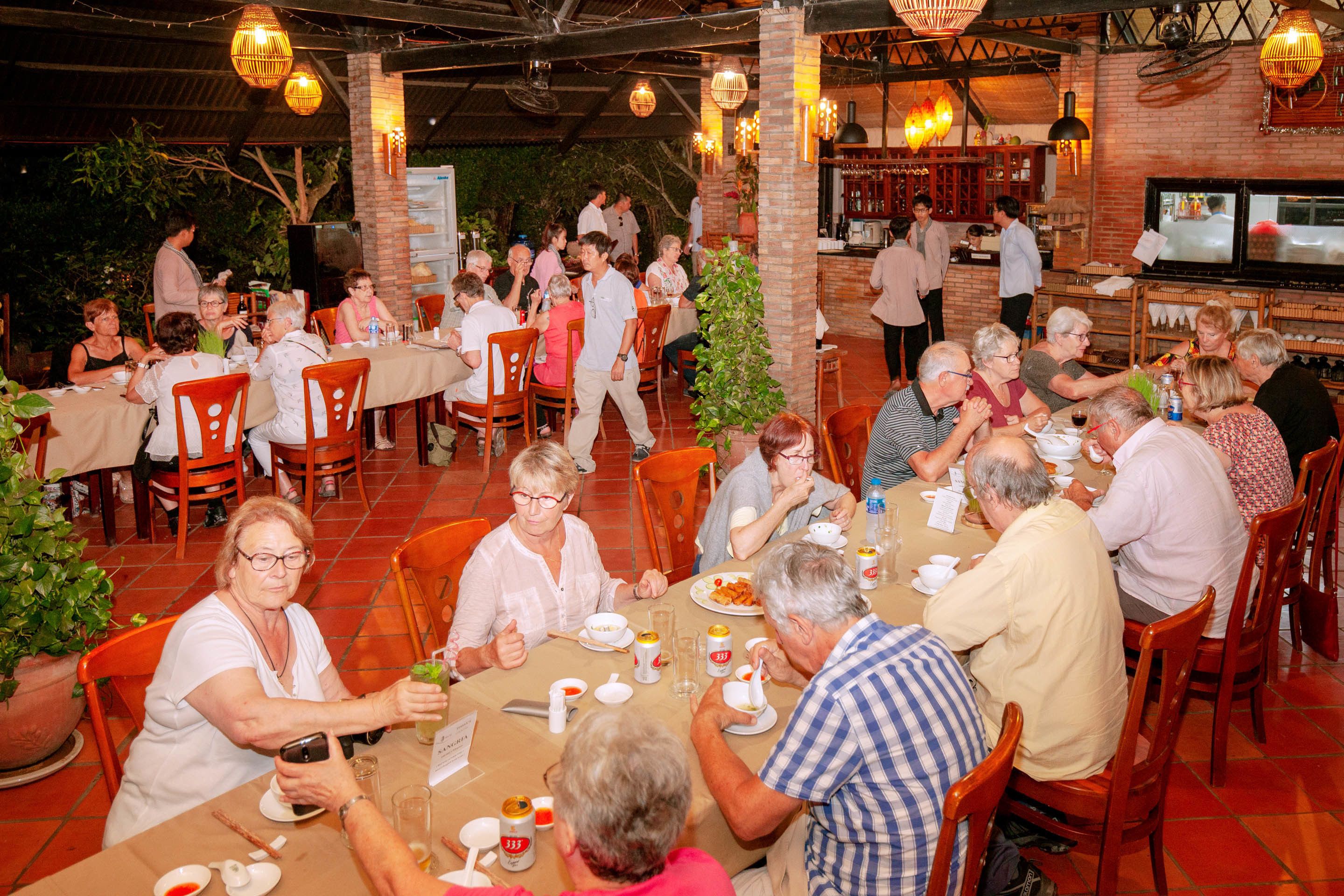 Un restaurante con terraza, paredes de ladrillo y luces colgantes.