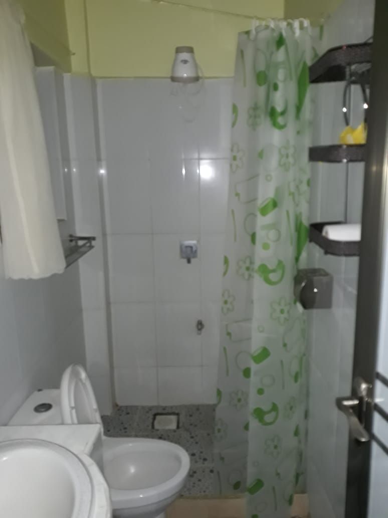 A bathroom with a shower, toilet, and sink.