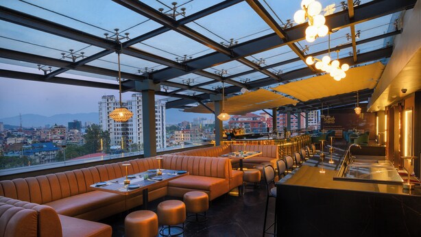 A rooftop bar with leather seating and a city view. - Hotel Le Himalaya (Kathmandu)