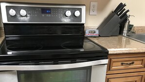 A kitchen with a double oven, a stove, and wooden cabinets. - Delta Dome Home Basement Apartment (Delta Junction)