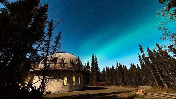 A dome-shaped building surrounded by trees under a starry night sky. - Delta Dome Home Basement Apartment (Delta Junction)