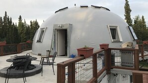 A dome-shaped structure with a door, windows, and a small table with chairs on the roof. - Delta Dome Home Basement Apartment (Delta Junction)