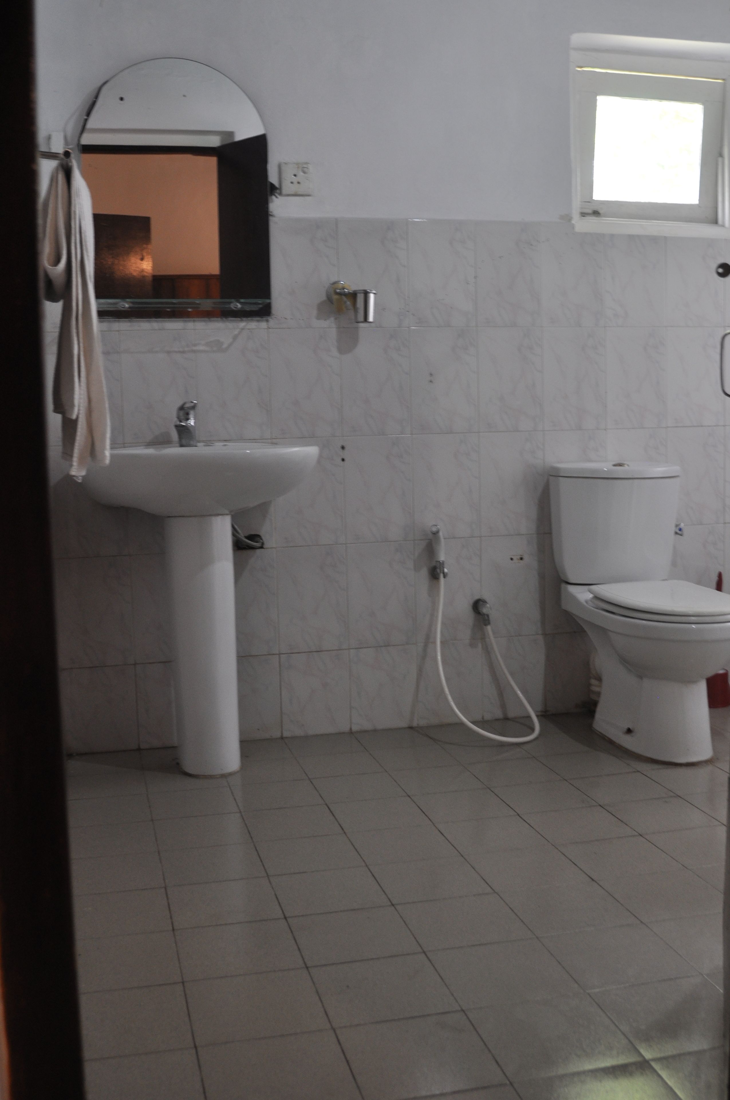 A bathroom with a white sink, a toilet, and a mirror.