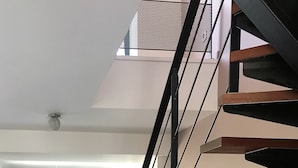 Een modern interieur met een trap die naar een hoger gelegen verdieping leidt.