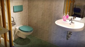 Ein Badezimmer mit Toilette, Waschbecken und Spiegel.