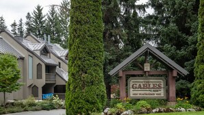 Une enseigne indiquant « The Gables », une résidence privée située sur Blackcomb Way, entourée d’une végétation luxuriante et d’une pelouse bien entretenue.