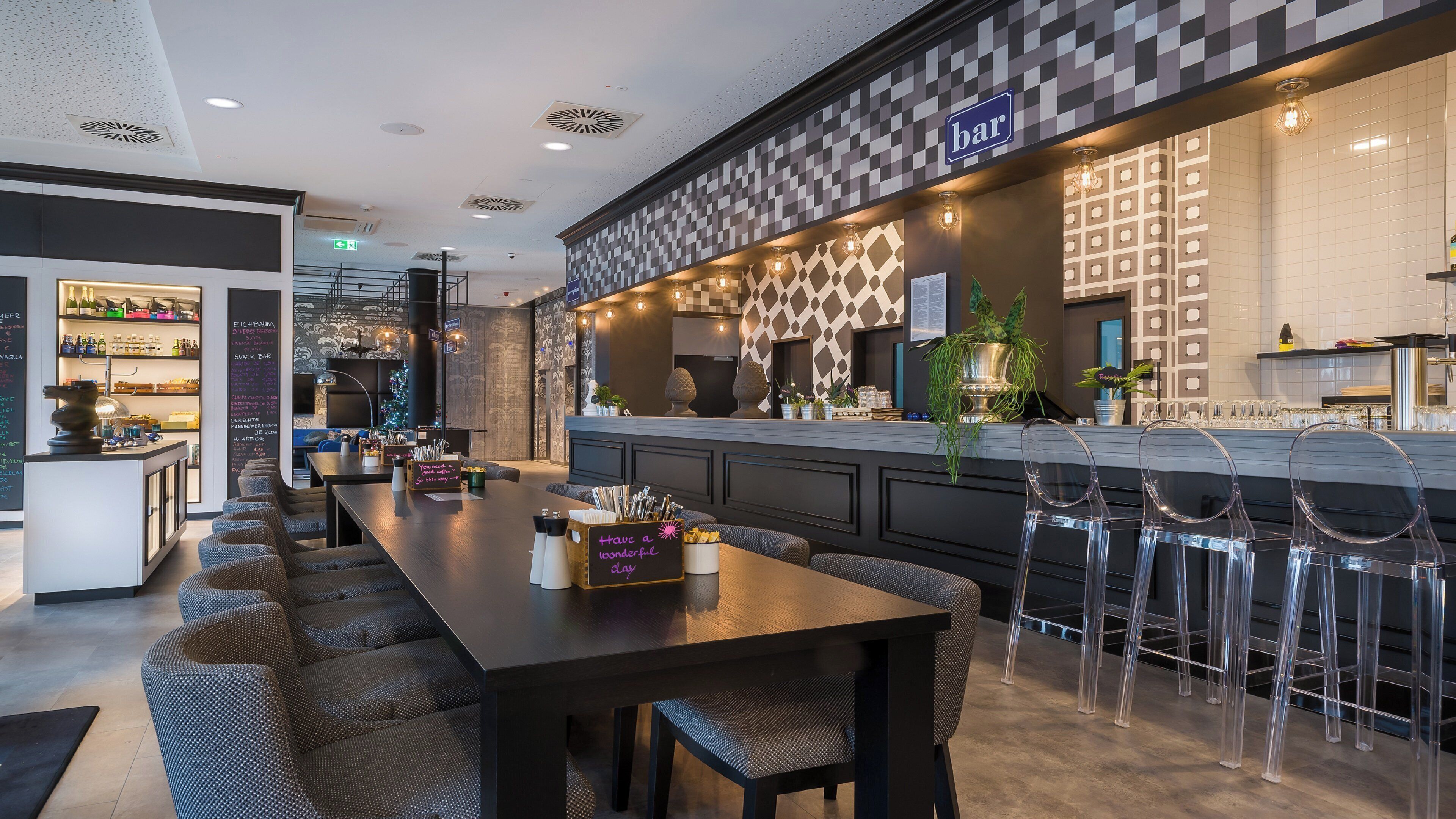 Eine Bar mit einer karierten Wand, Barhocker und einer langen Theke.