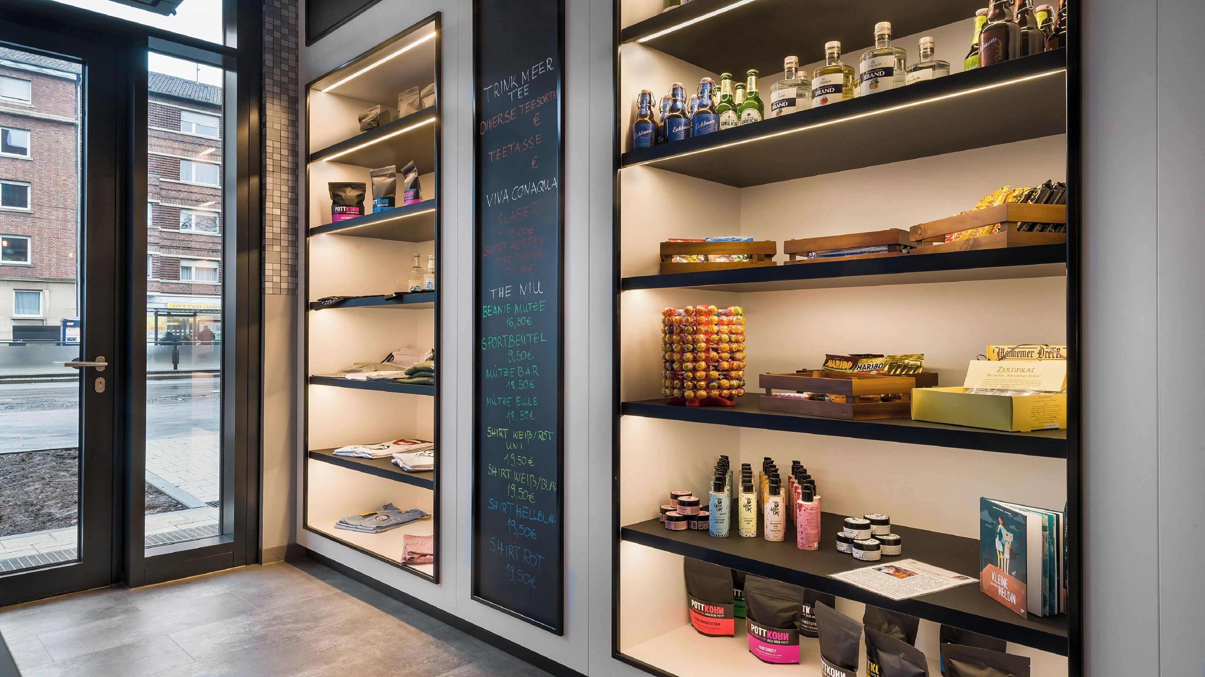 A retail space with shelves stocked with various products, including beverages, snacks, and toiletries.