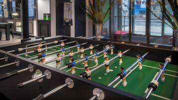 A foosball table with multiple players in a well-lit indoor setting.