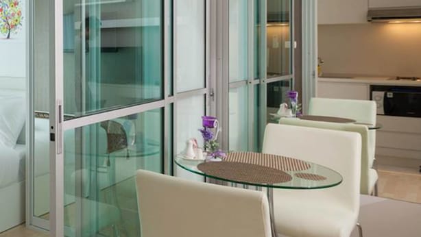 A modern kitchen with white cabinets and a black microwave. - The Cube Residence Government Complex Laksi (Bangkok)