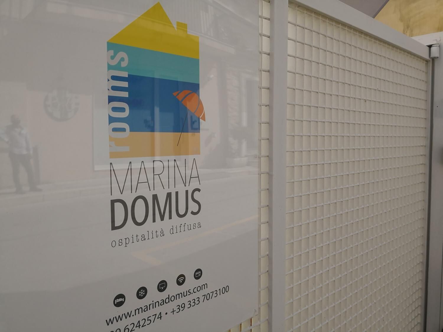 A sign for Marina Domus with contact information and a website URL.