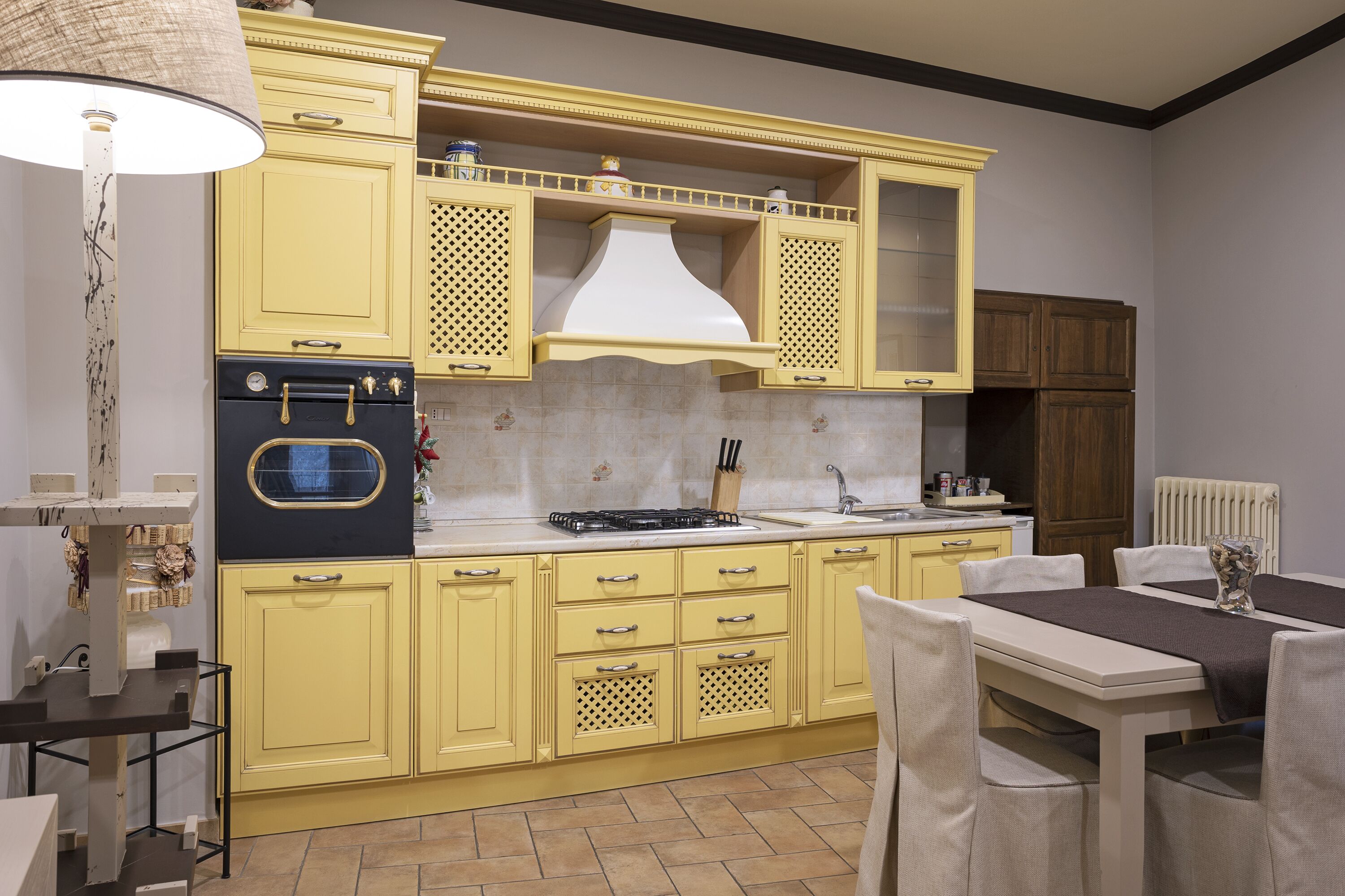 Una cocina con armarios amarillos, una estufa y un comedor con mesa y sillas.