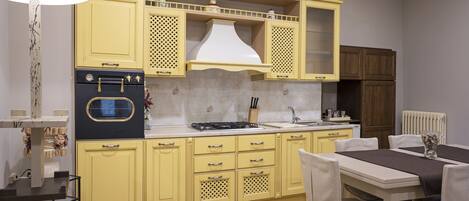Una cocina con armarios amarillos, una estufa y un comedor con mesa y sillas.