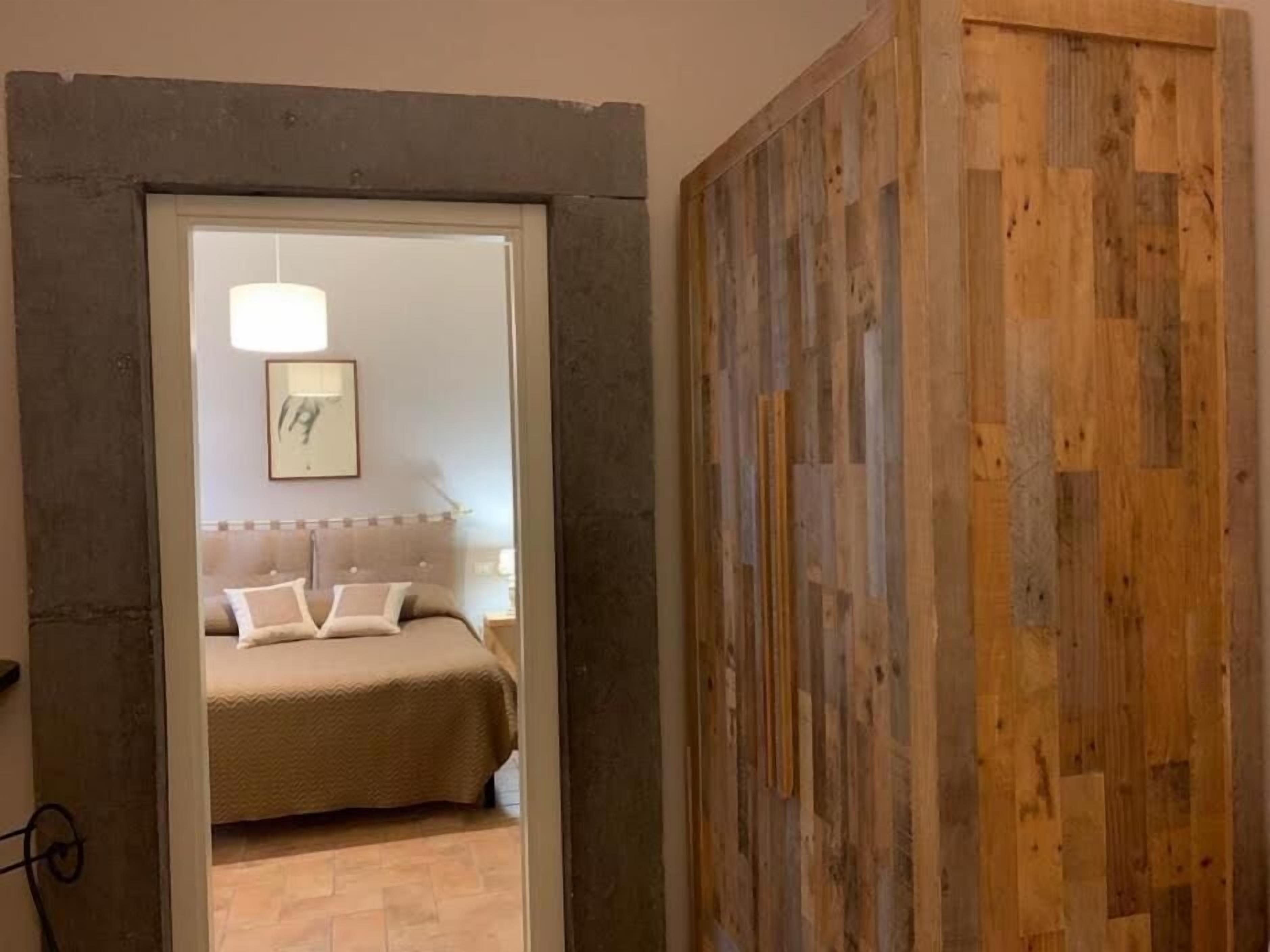 Een slaapkamer met een bed, nachtkastje en nachttafel.