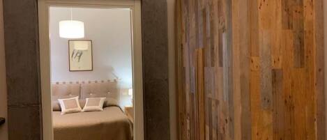 A bedroom with a bed, a bedside table, and a nightstand.