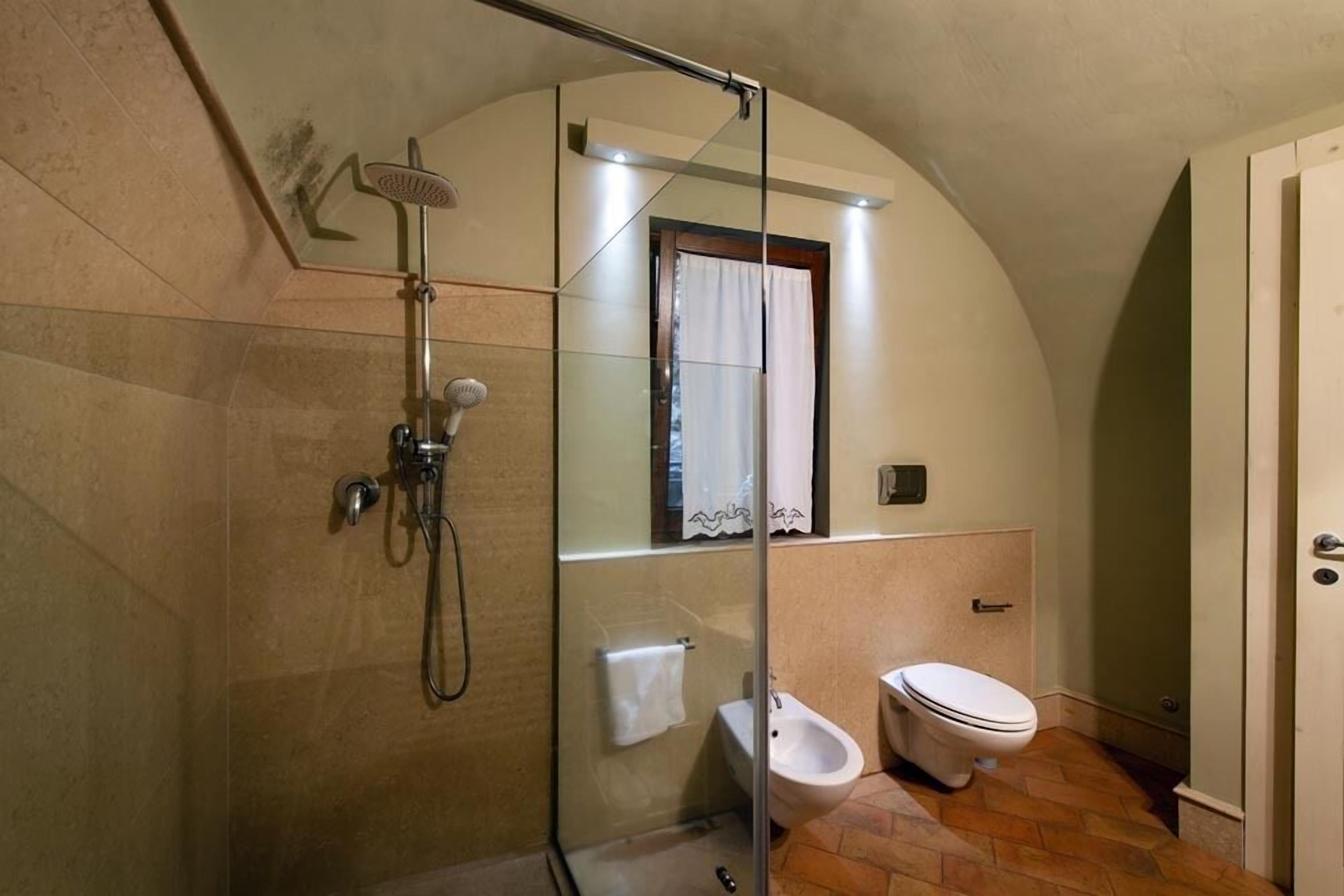 Un baño con ducha de vidrio, inodoro y bidé.