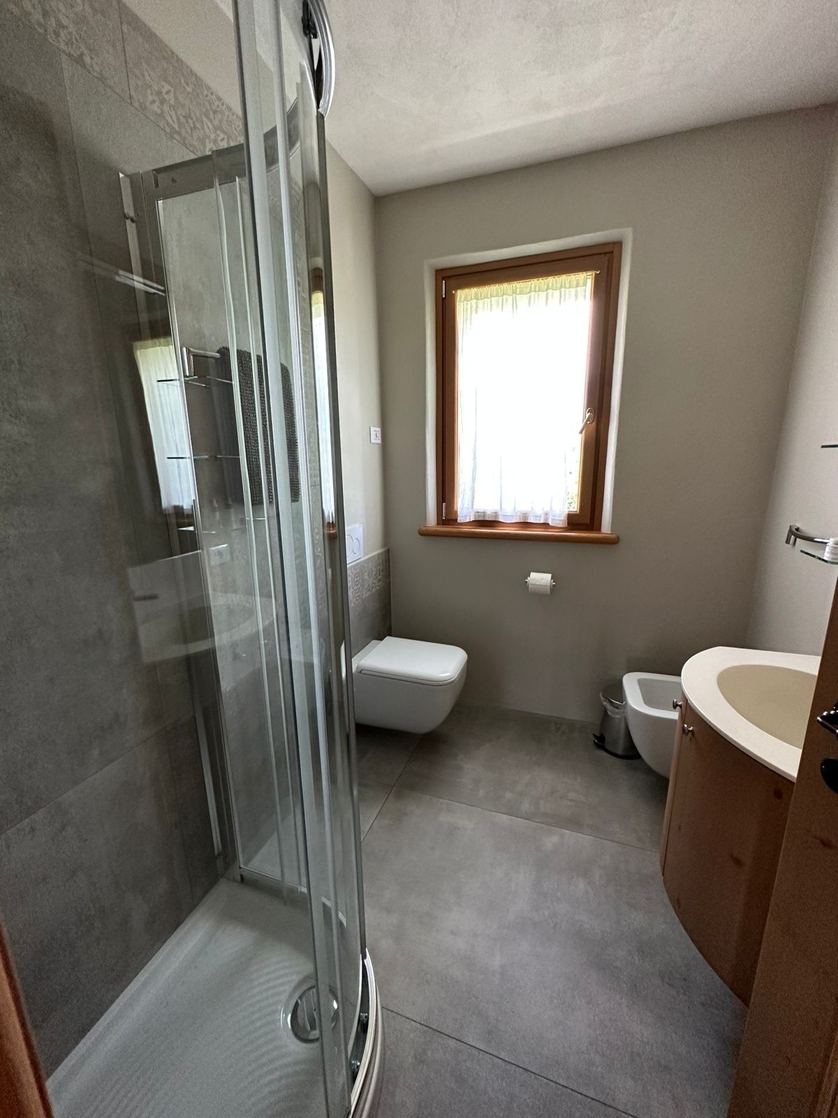 Ein Badezimmer mit Duschkabine, Toilette und Waschbecken.