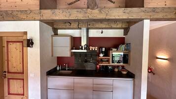 A compact kitchen with wooden cabinetry, a built-in stove, and a small countertop.