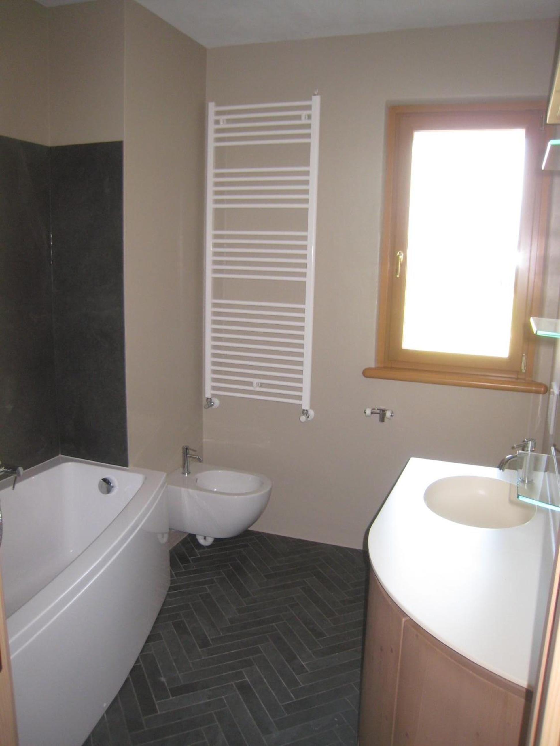 A bathroom with a bathtub, bidet, and sink.