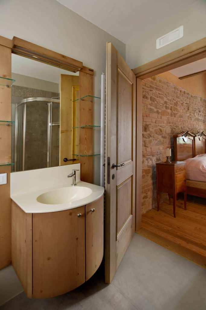 Un baño con tocador de madera, un espejo y cabina de ducha.