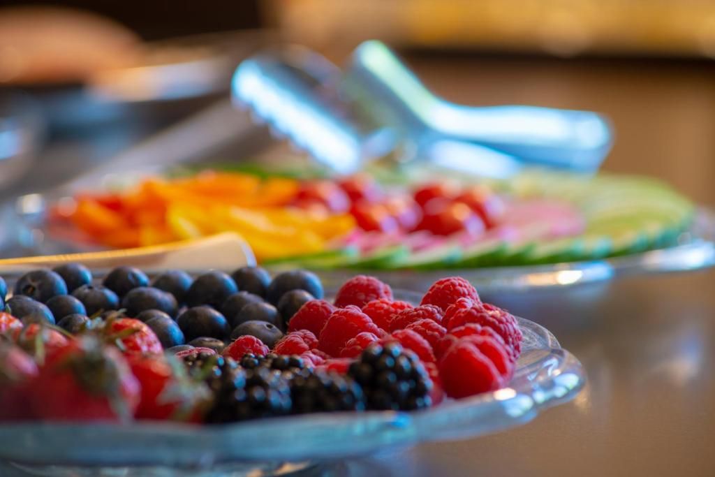 A buffet with various fruits including berries and sliced fruits.