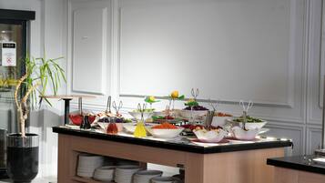 Disposição de buffet com diversos alimentos e utensílios.