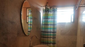 Une salle de bain avec un lavabo, des toilettes et une douche.