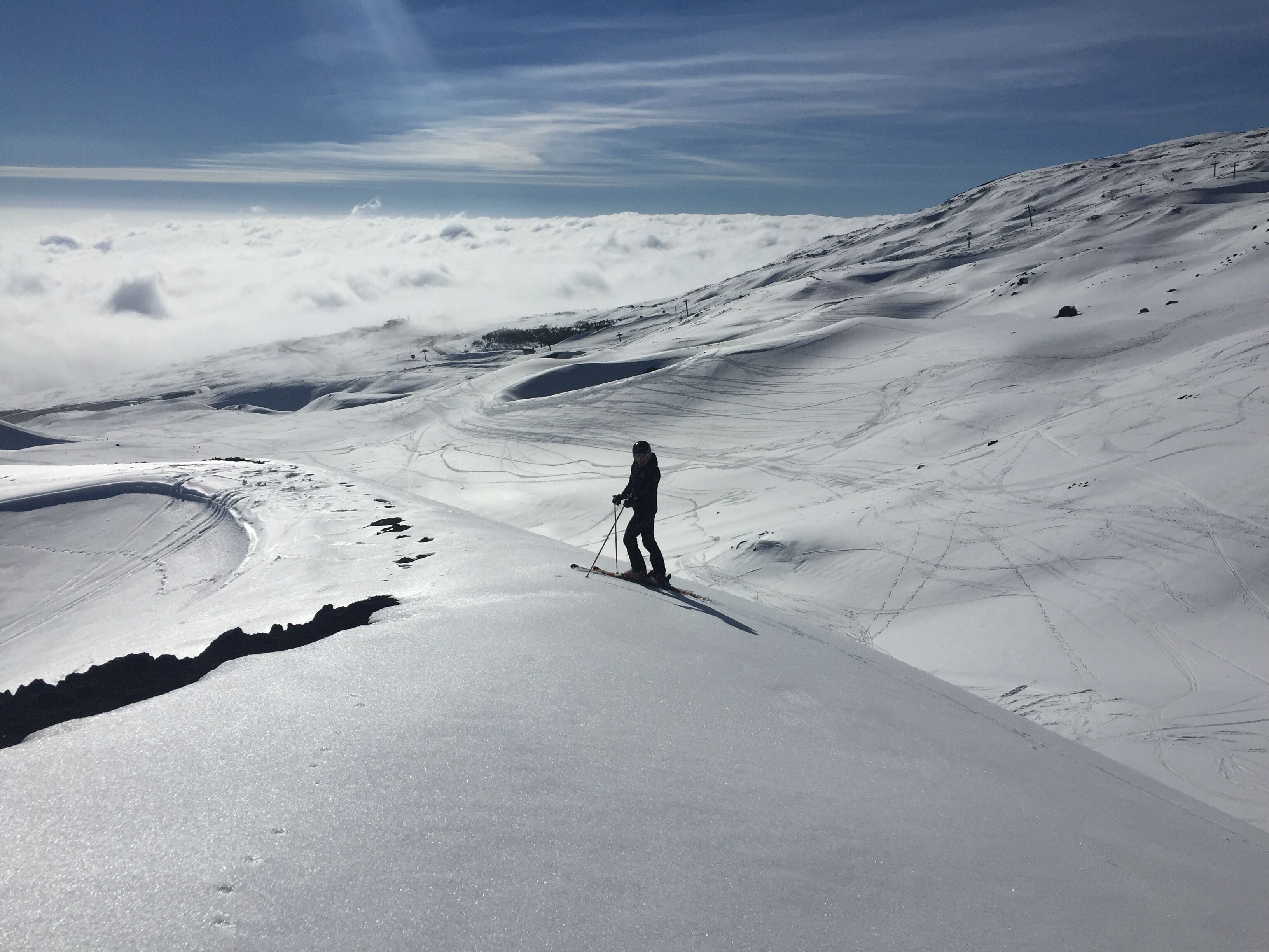 A snowy mountain landscape with a skier.