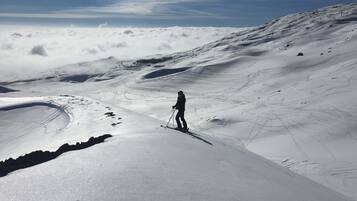 A snowy mountain landscape with a skier.