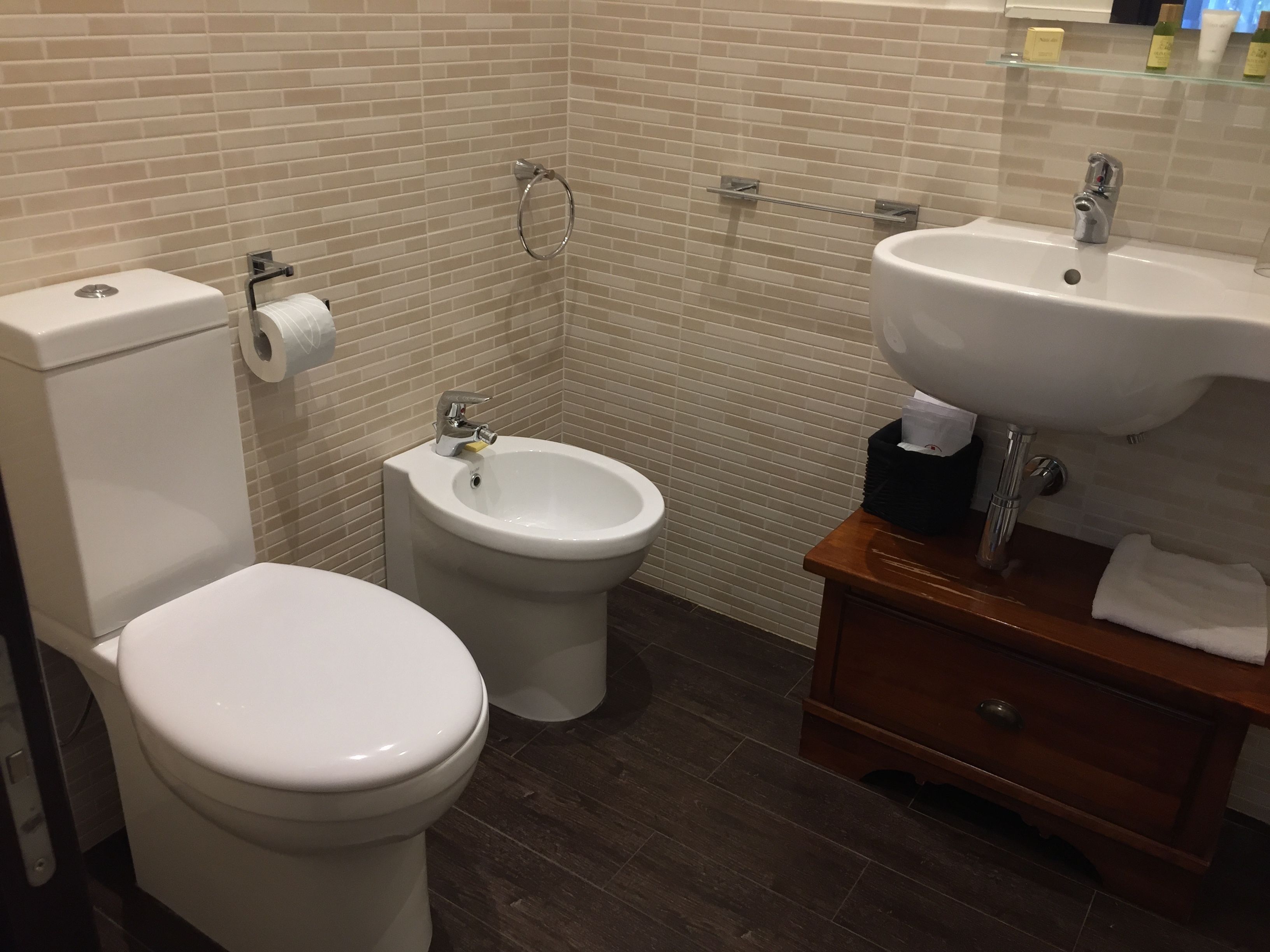 A bathroom with a toilet, bidet, and sink.