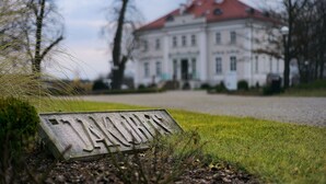 A sign with the name "JERUSALEM" in a grassy area with a building in the background. - Jakubus (Wilków)