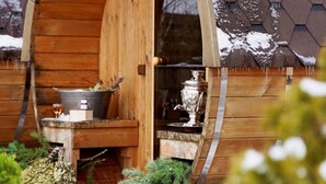 A wooden cabin with a rustic exterior, a metal bucket, and a silver pot on the porch. - Jakubus (Wilków)