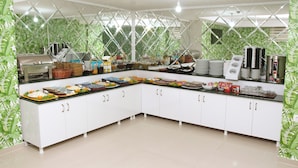 A buffet setup with various food items, a coffee machine, and a beverage dispenser. - Green Garden Hotel (Istanbul)