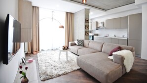 Una sala de estar moderna con un sofá, un televisor, una mesa de centro y una alfombra.