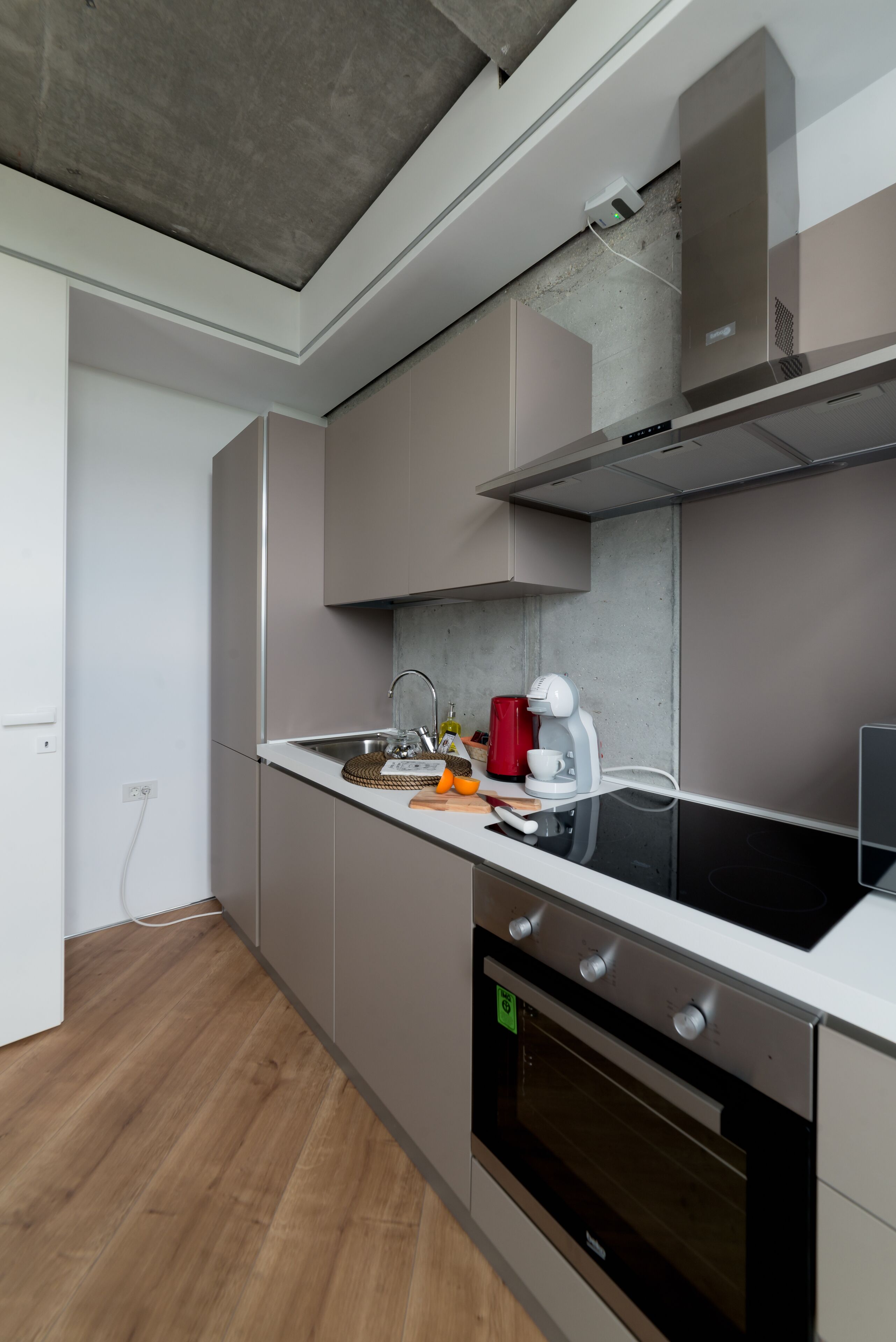 Una cocina moderna con horno empotrado, electrodomésticos de acero inoxidable y un diseño minimalista.