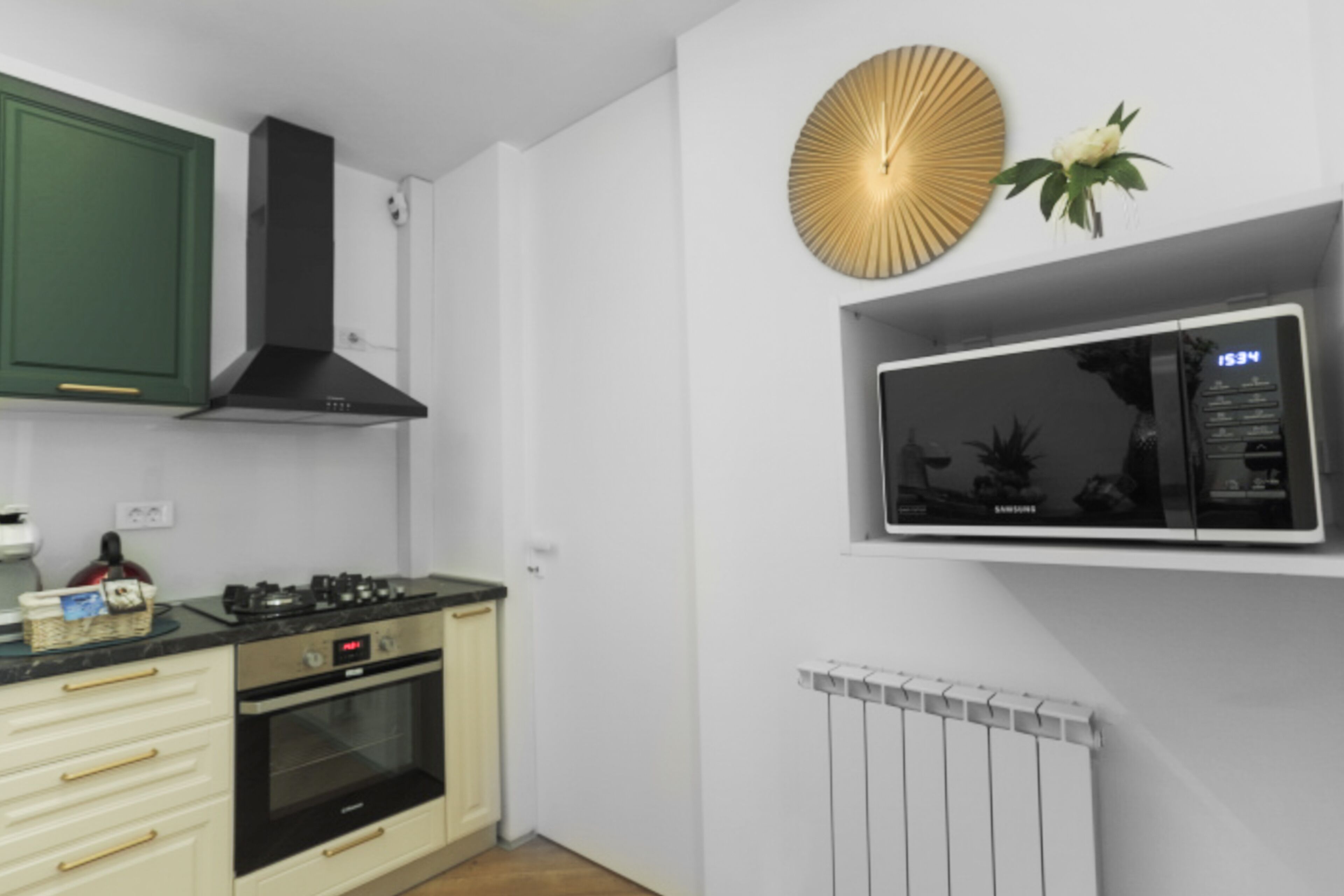 A modern kitchen with white cabinets, a black stove, and a built-in microwave above the counter.