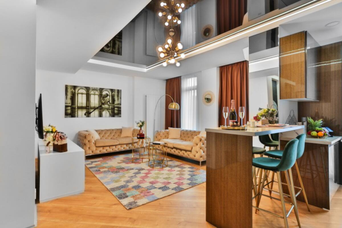 A modern living room with a sofa, a coffee table, and a kitchen area with a bar.