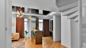 Un interior moderno con comedor, cocina y escalera.