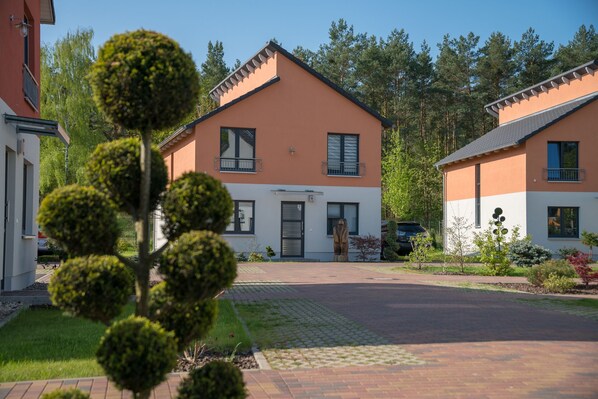 A two-story residential building with a symmetrical facade, a central entrance, and a small porch area. - Ferienpark Rübezahl am Müggelsee (Berlin)