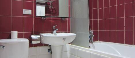 A bathroom with a toilet, sink, and bathtub.