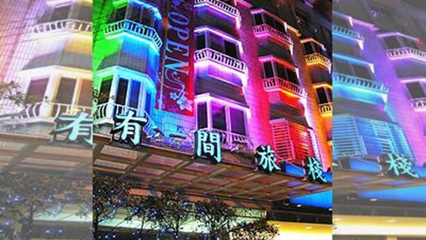 Un edificio de varios pisos con balcones y un cartel con caracteres chinos.
