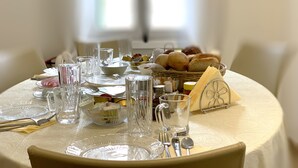 A table set for a meal with clear glassware, plates, and silverware. - Avgi's Home (Limassol)