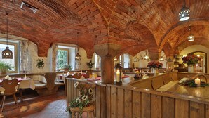 A rustic interior with brick arches, wooden furniture, and a central bar area. - Osserhotel (Lohberg)