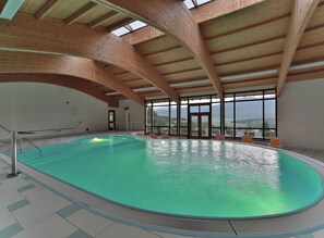 Una piscina techada, sillones reclinables de piscina