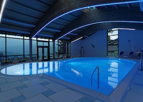 Una piscina techada, sillones reclinables de piscina