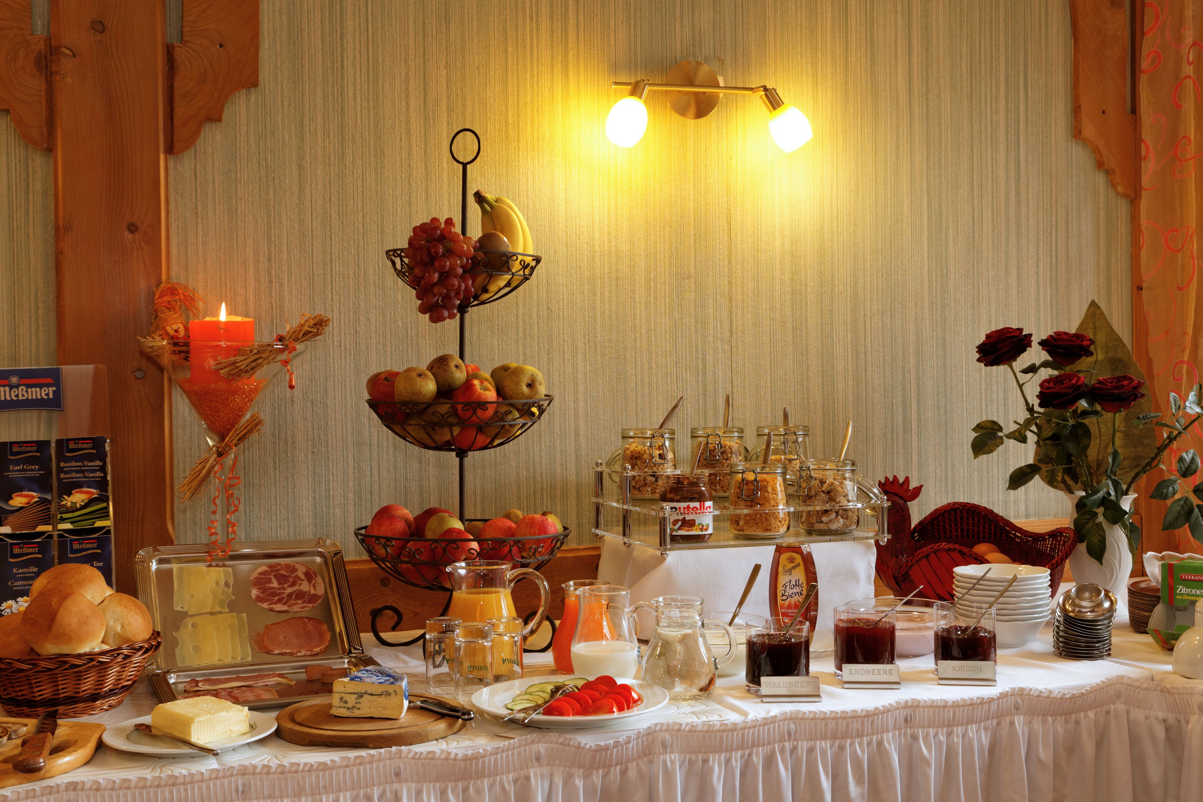A breakfast buffet with various food items and a candle.